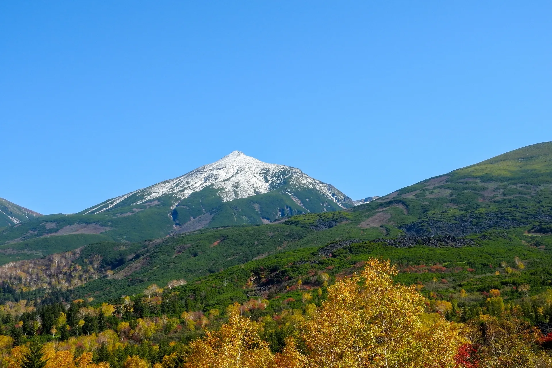 夕日が沈む空と、蛇行する川が美しく輝く広大な田園風景の空撮写真